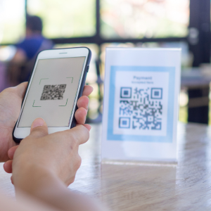 QR Code Example, phone pointed at a paper QR code sitting on a desk