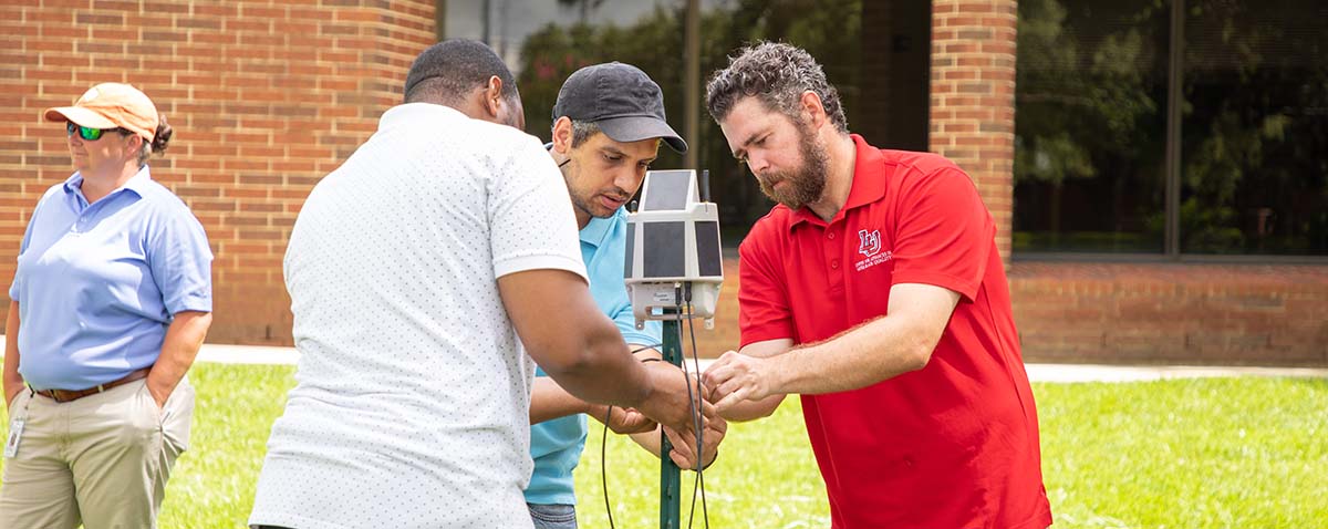 Far right: Dr. Nicholas Brake demonstrating how the flood sensors work.